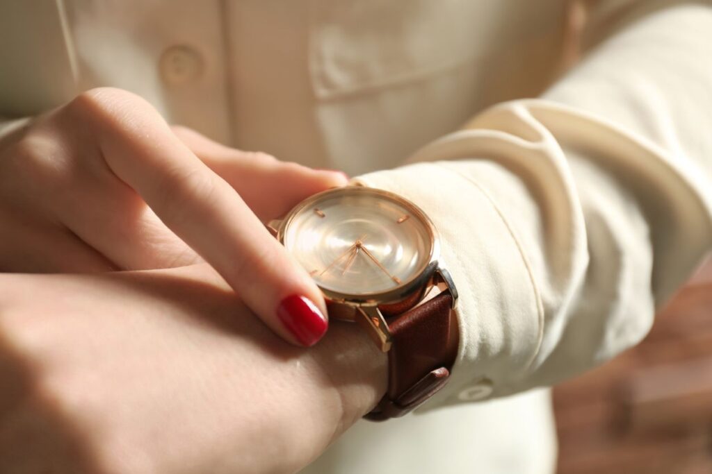lady in an expensive cream blouse looking at her watch